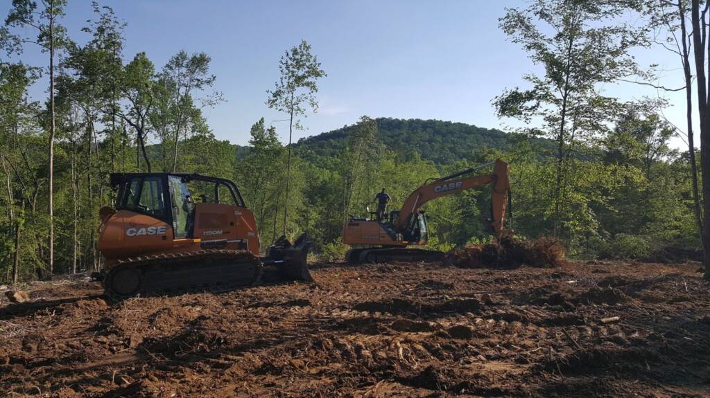 excavator and bobcat clearing land