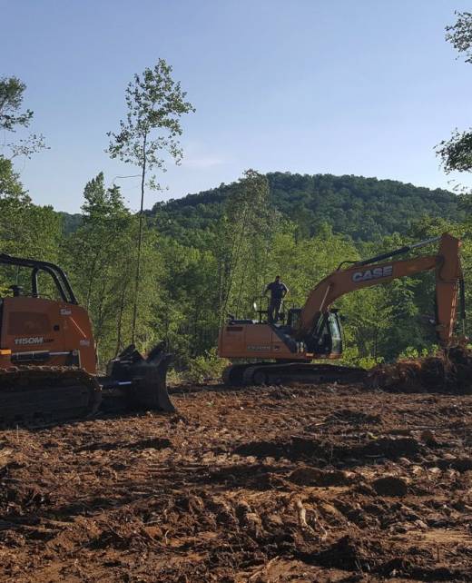 excavator and bobcat clearing land